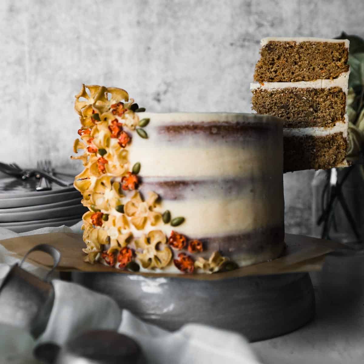 the first slice slice being lifted from a three-layer carrot spice cake.