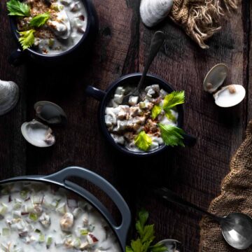 a bowl full of clam chowder sprinkled with paprika.