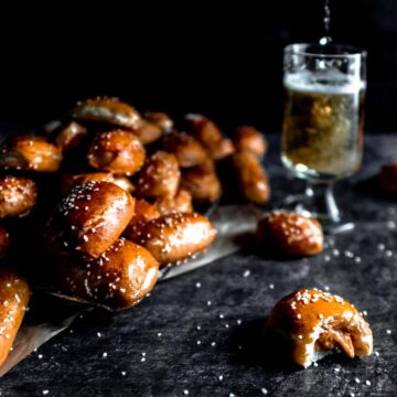 Peanut Butter filled pretzel nugget with a bite taken out and a beer being poured in the background