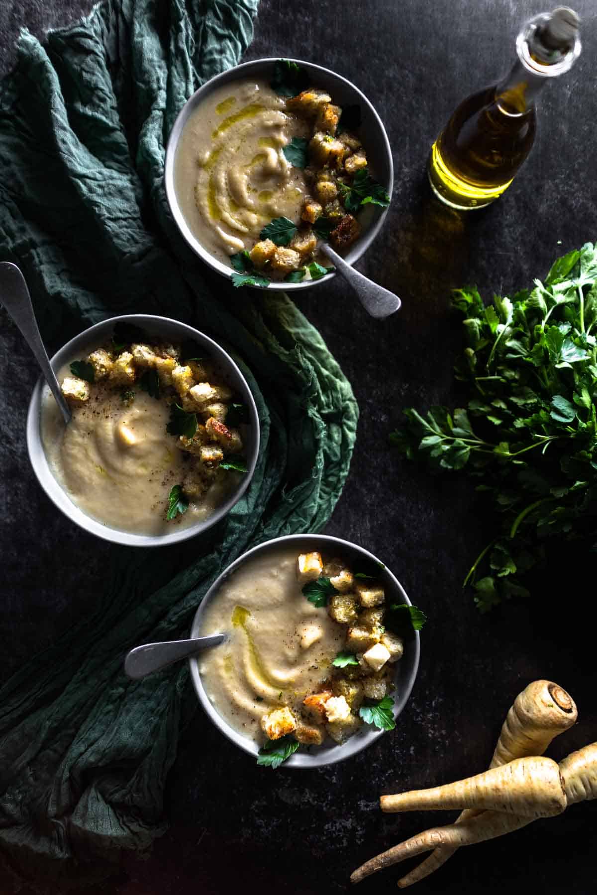 overhead shot of 3 bowls of vegan parsnip soup