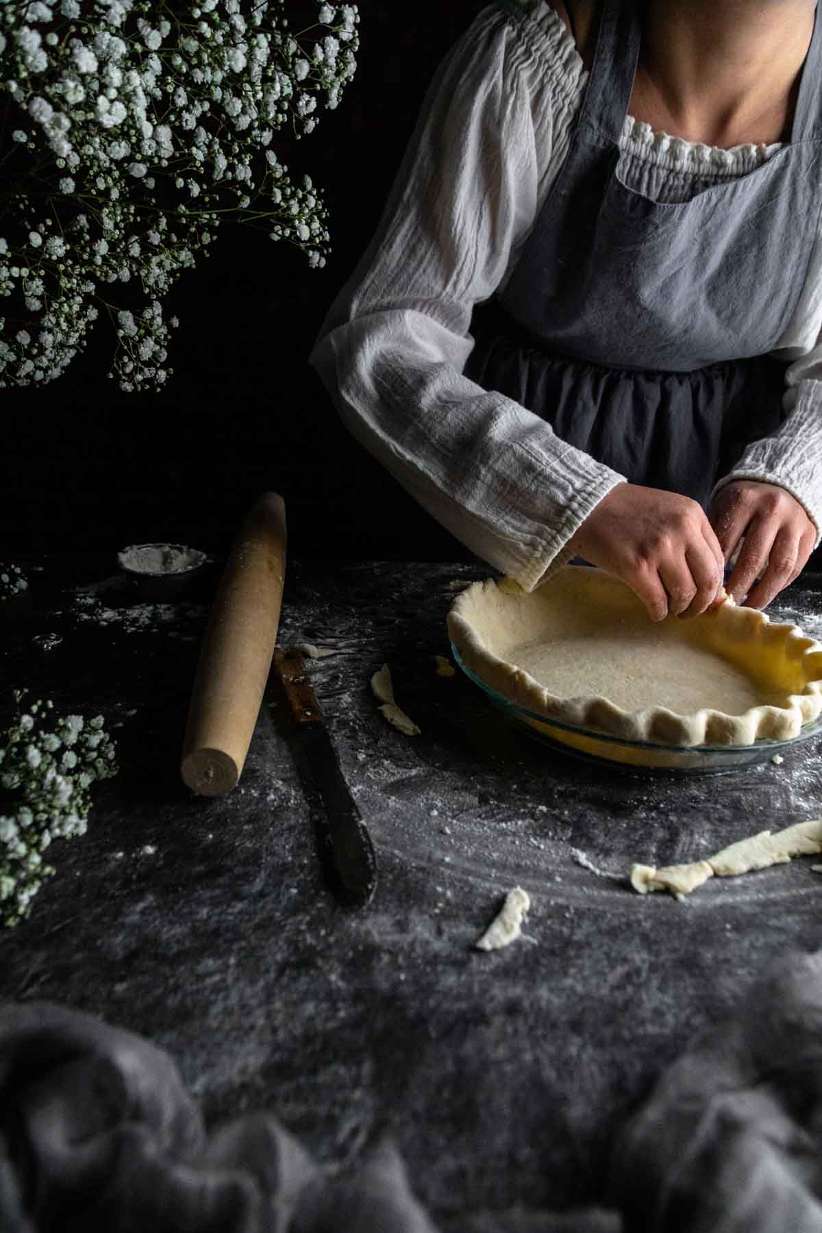 A woman crimping a homemade buttery pie dough