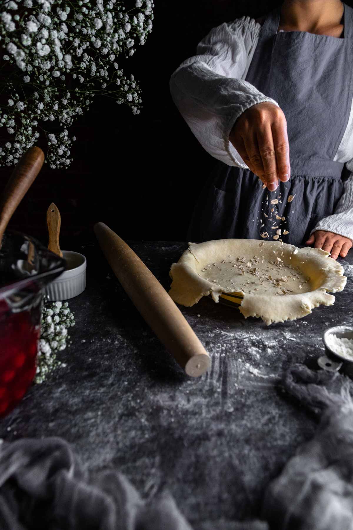 Sprinkling oats into a pie crust to prevent a soggy bottom