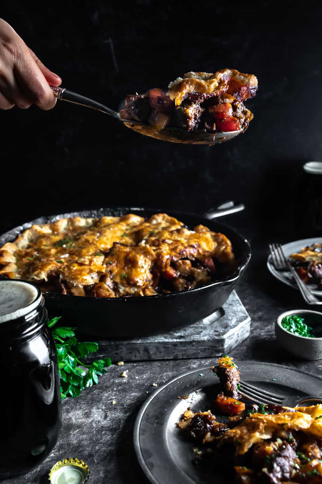 a serving spoon with a big scoop of braised lamb pie