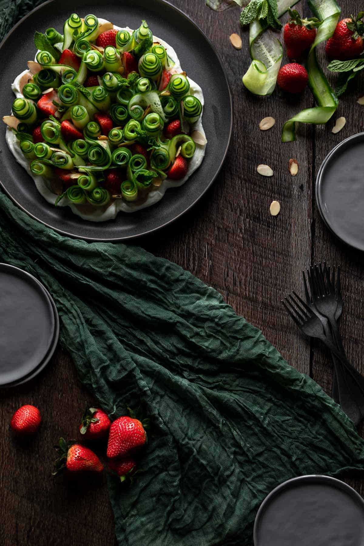 overhead view of cucumber strawberry salad alongside ingredients