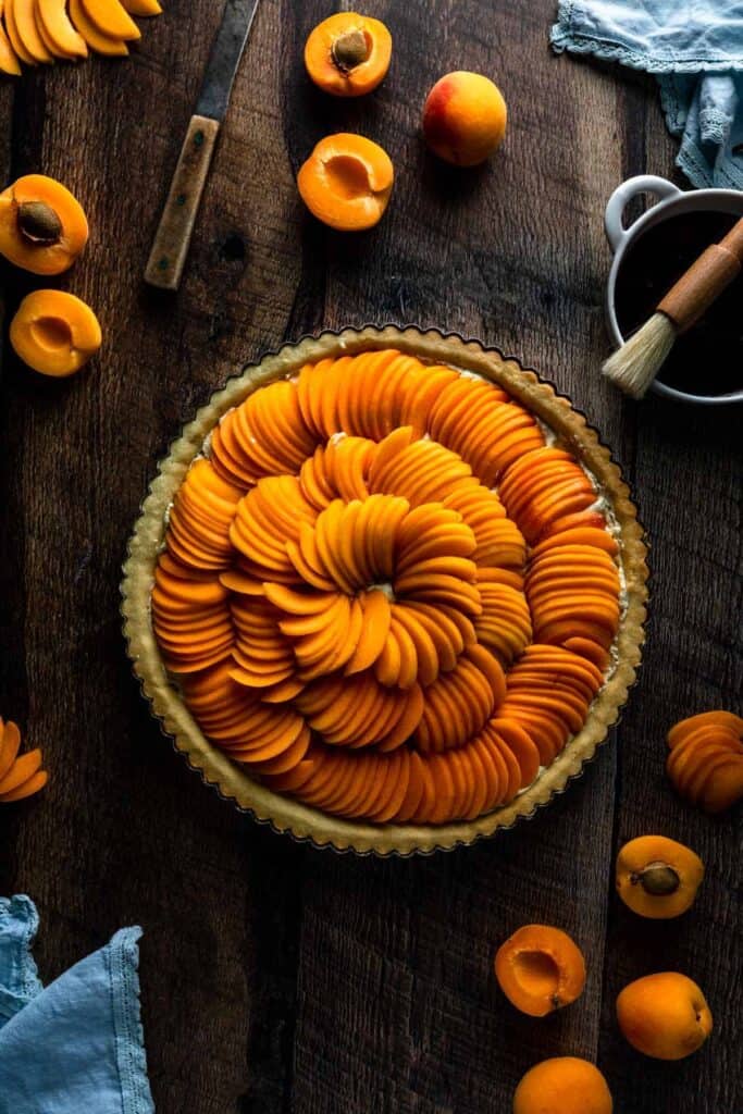 An unbaked apricot tart filled with shingled slices of fresh apricot