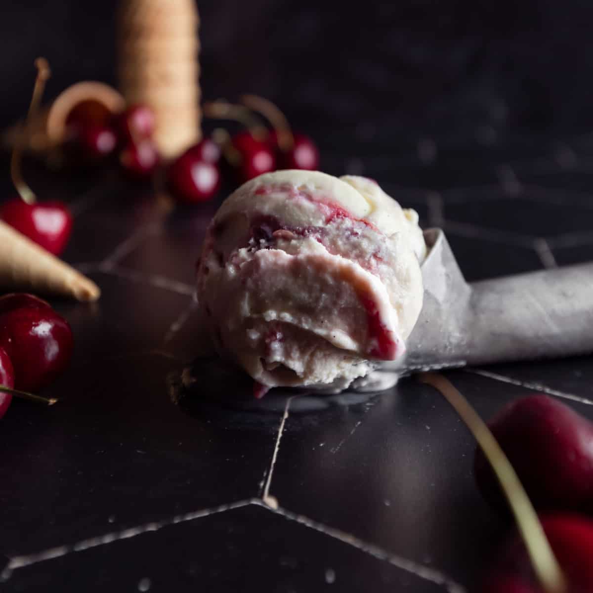 A close up of a scoop of cherry vanilla ice cream