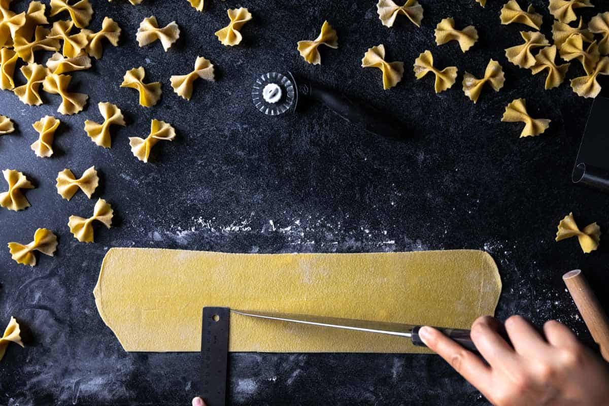 Using a ruler to measure a sheet of semolina pasta dough