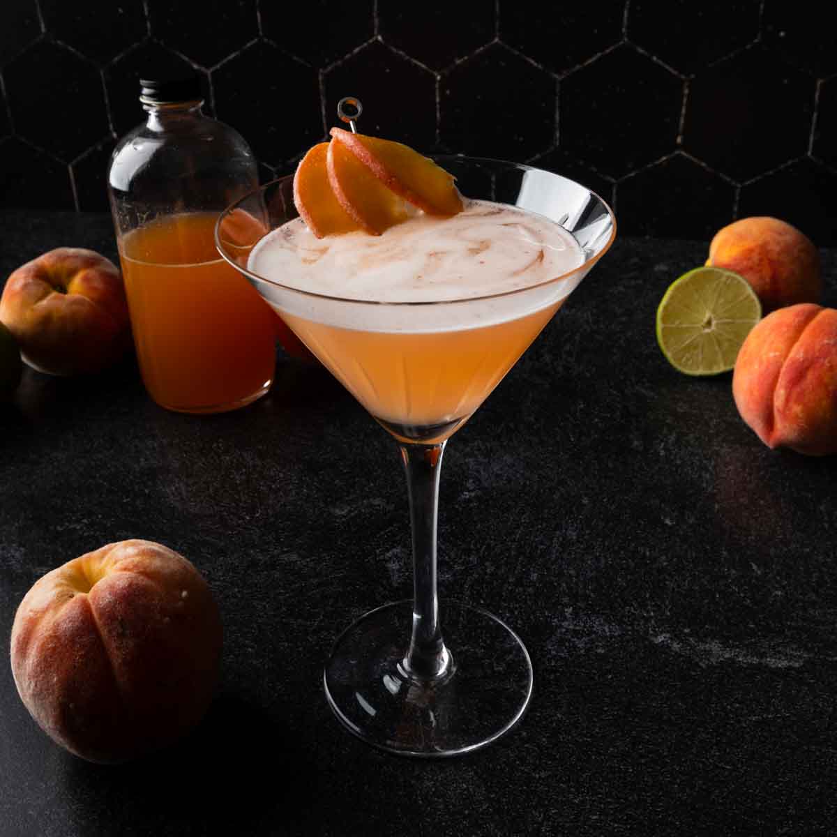 A martini glass with a peach daiquiri garnished with a fan of fresh peach slices. 