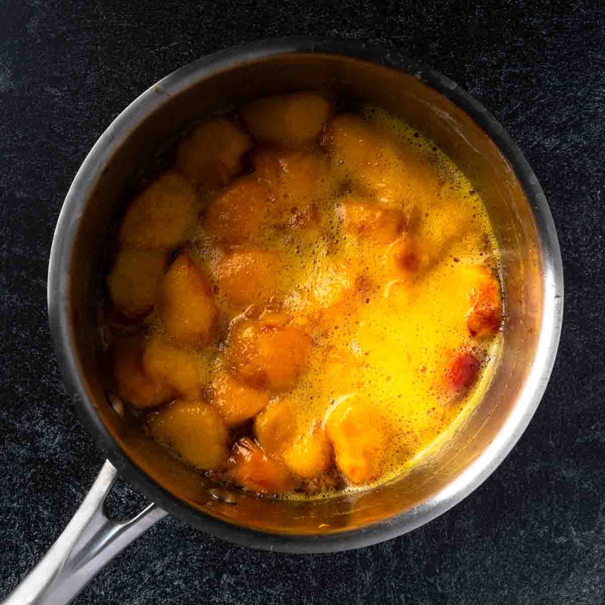 A pot of boiling peach syrup.