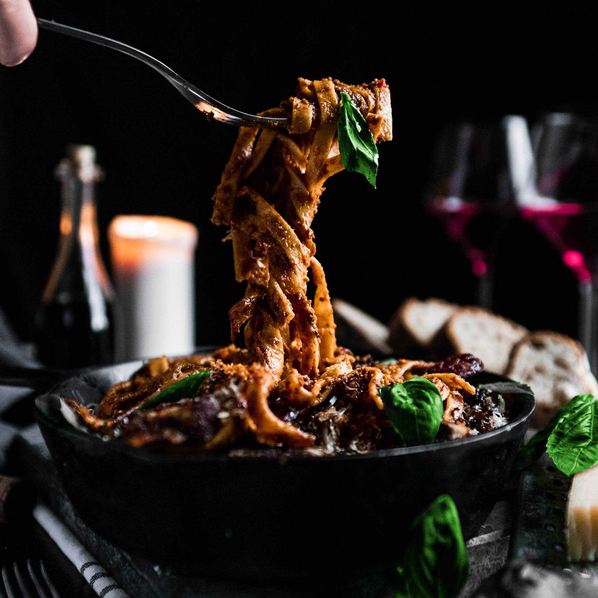 A fork twirling a scoop of homemade fettuccine sun-dried tomato Alfredo