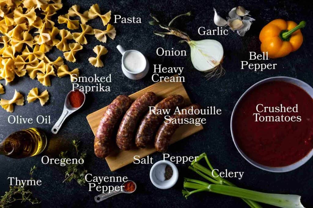 Ingredients for Cajun pasta: andouille sausage, farfalle. heavy cream, crushed tomatoes, olive oil, oregano, thyme, cayenne pepper, celery, onion, garlic, bell pepper, smoked paprika, salt and pepper