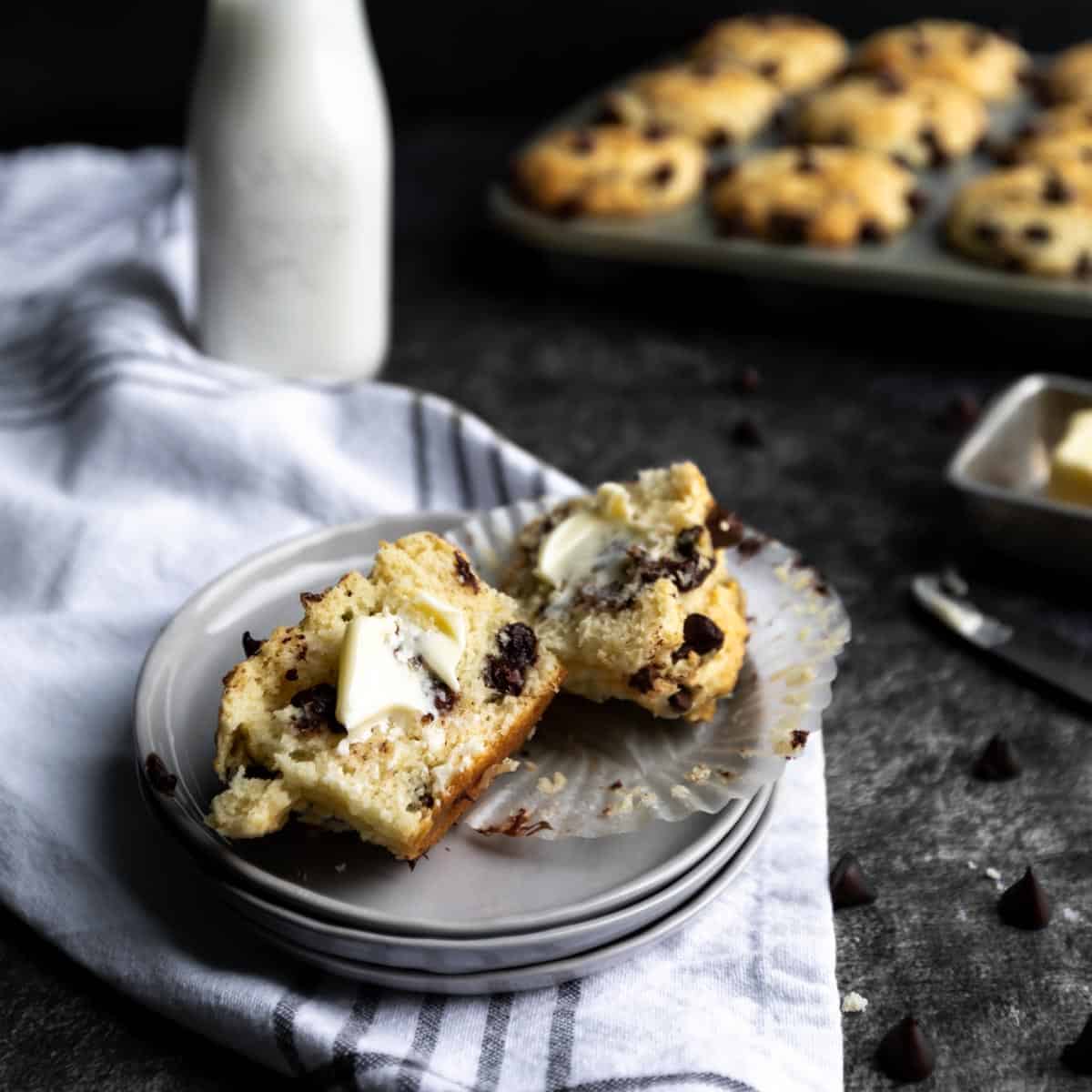 a Chocolate chip muffin that has been cut in half and buttered