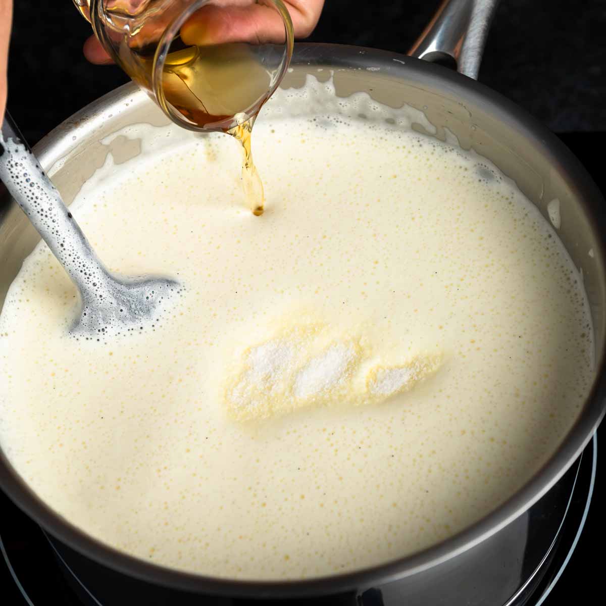 Pouring bourbon into the hot custard