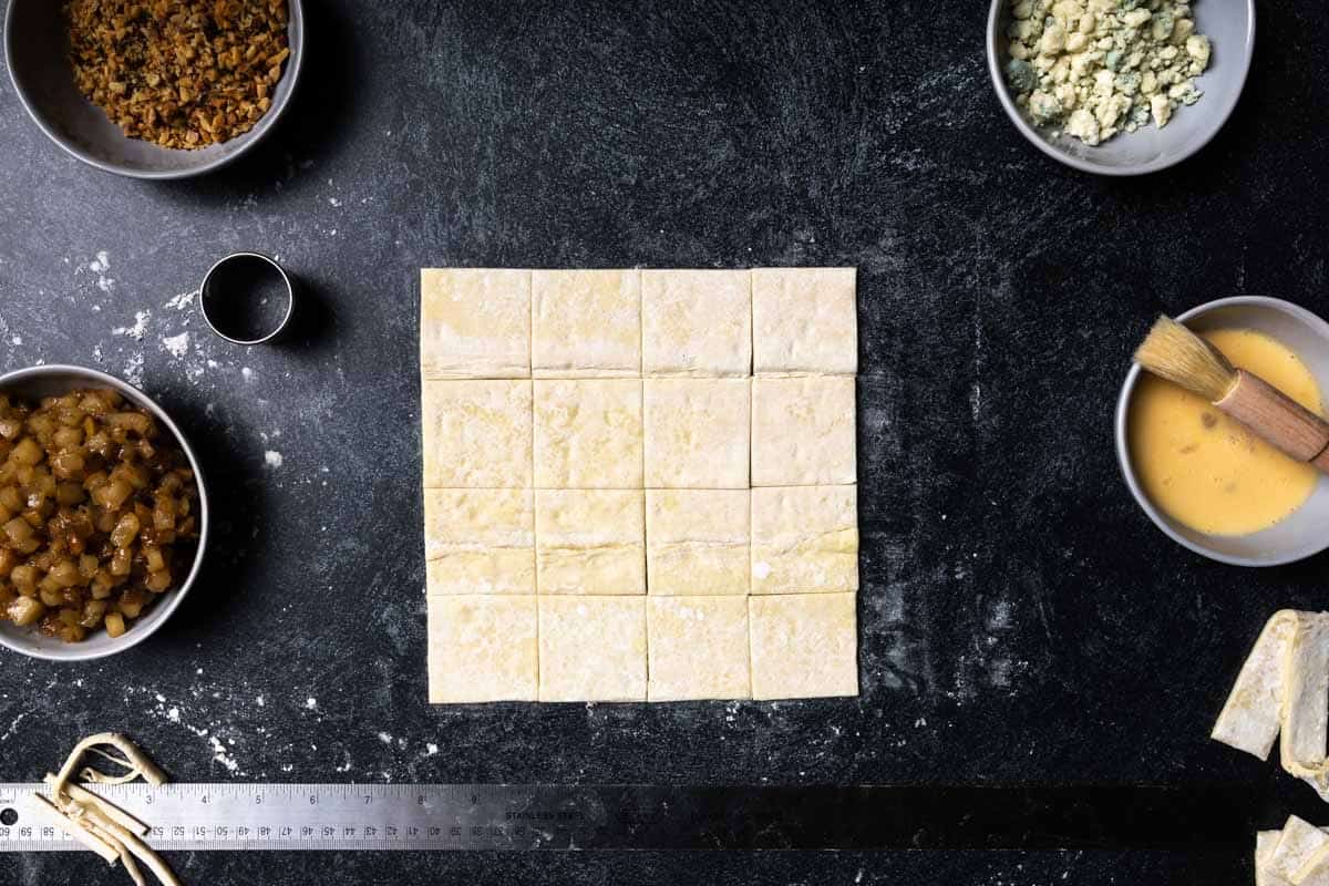 A square of puff pastry dough cut into bite-sized squares