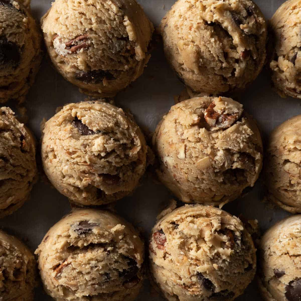 scooped portions of coconut pecan chocolate chip cookie dough lined up side by side