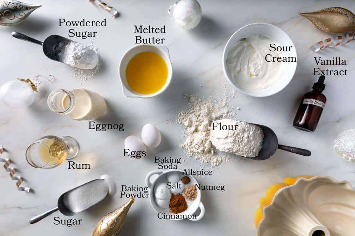 Ingredients for this Christmas cake including eggnog, sour cream, flour, sugar, butter, eggs, rum, powdered sugar, baking powder, baking soda, salt, cinnamon, nutmeg and allspice