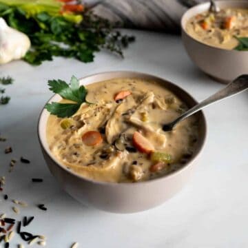 A bowl of Panera Copycat creamy chicken and wild rice soup on a white countertop