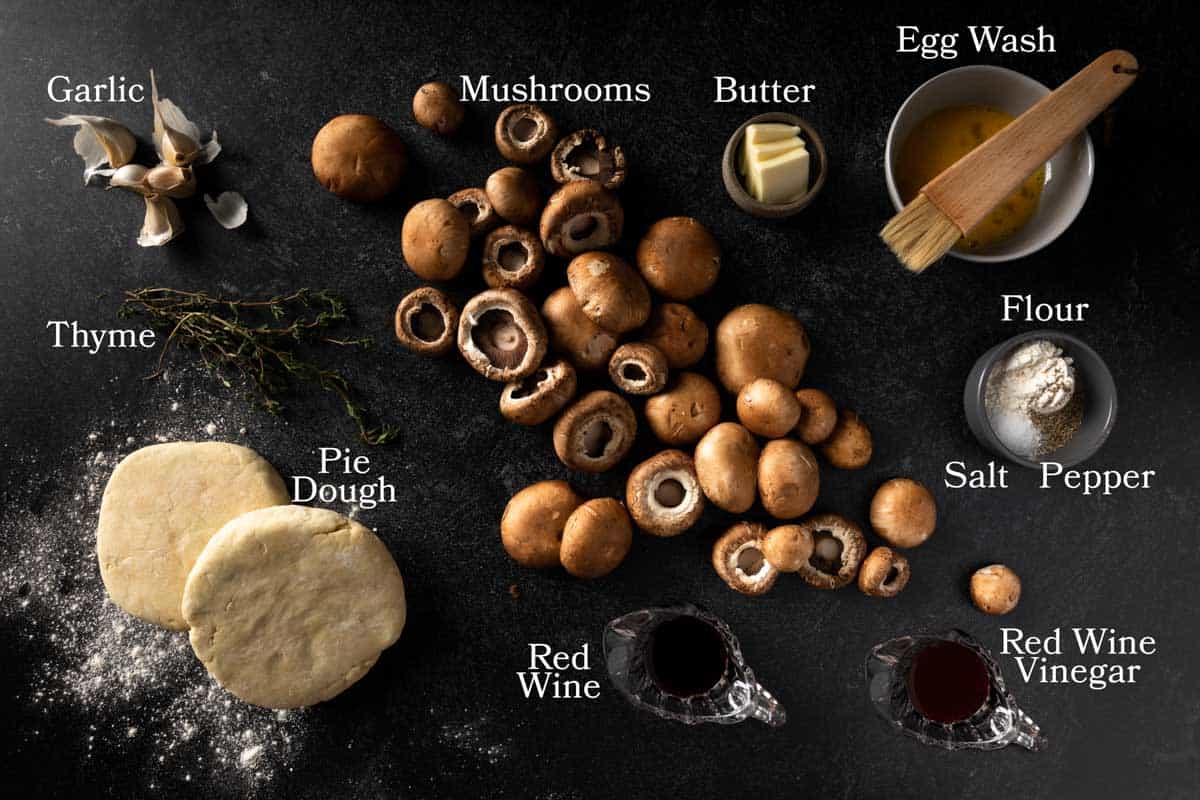 A photo of the ingredients for this recipe including mushrooms, pie dough, garlic, thyme, butter, flour, salt, pepper, red wine, red wine vinegar and egg wash