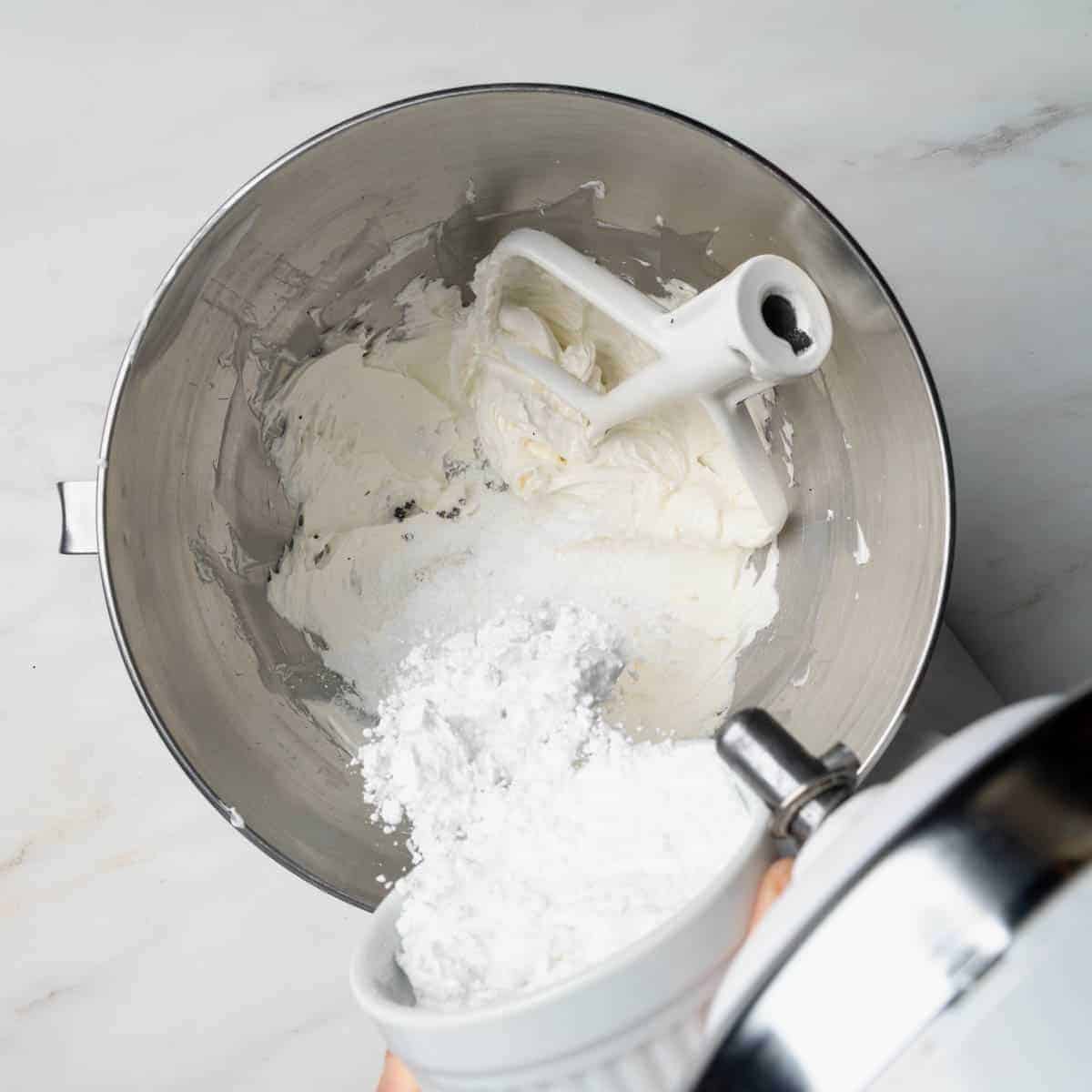 Adding powdered sugar to the buttercream