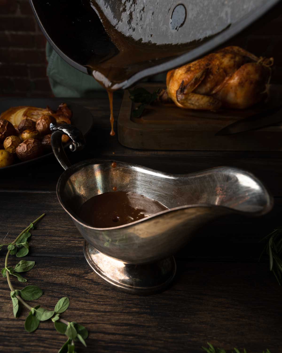 Pouring the white wine pan sauce into a big gravy boat.