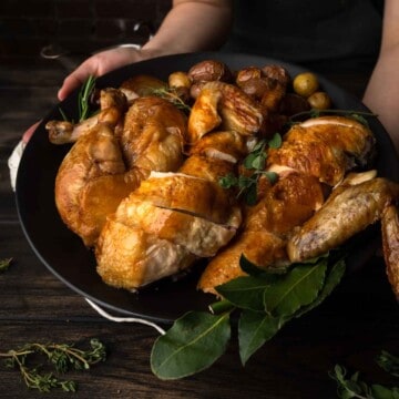 A close up image of a platter of herb roasted chicken