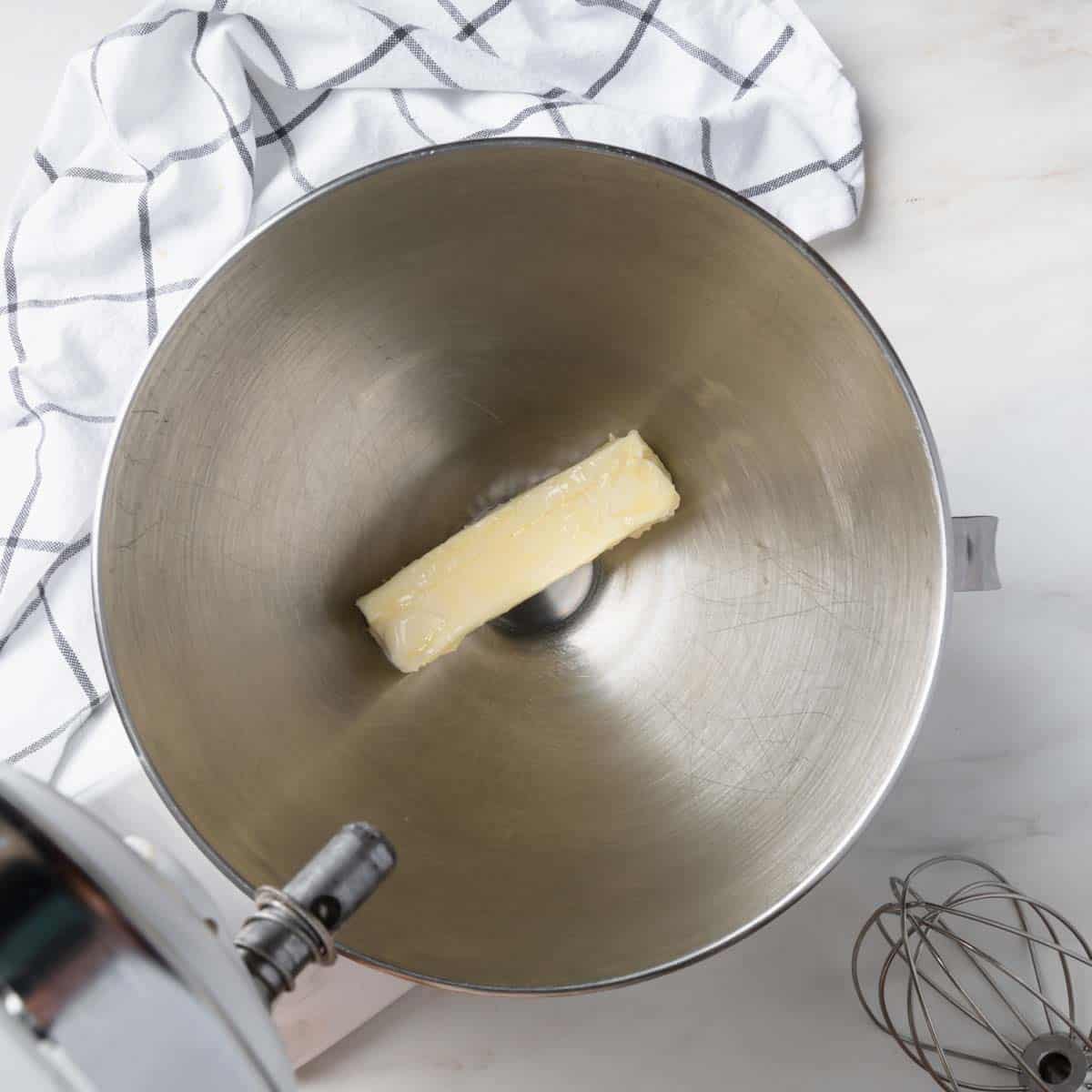 A stick of softened butter in a stand mixer