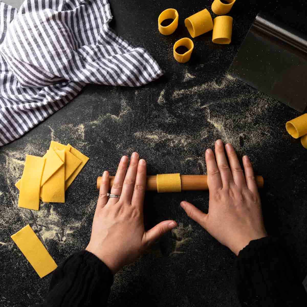 Shaping homemade paccheri around a mini rolling pin