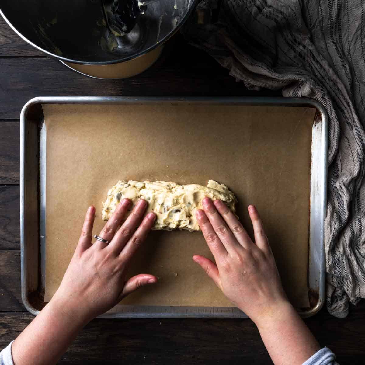 Patting the log of biscotti dough with wet hands