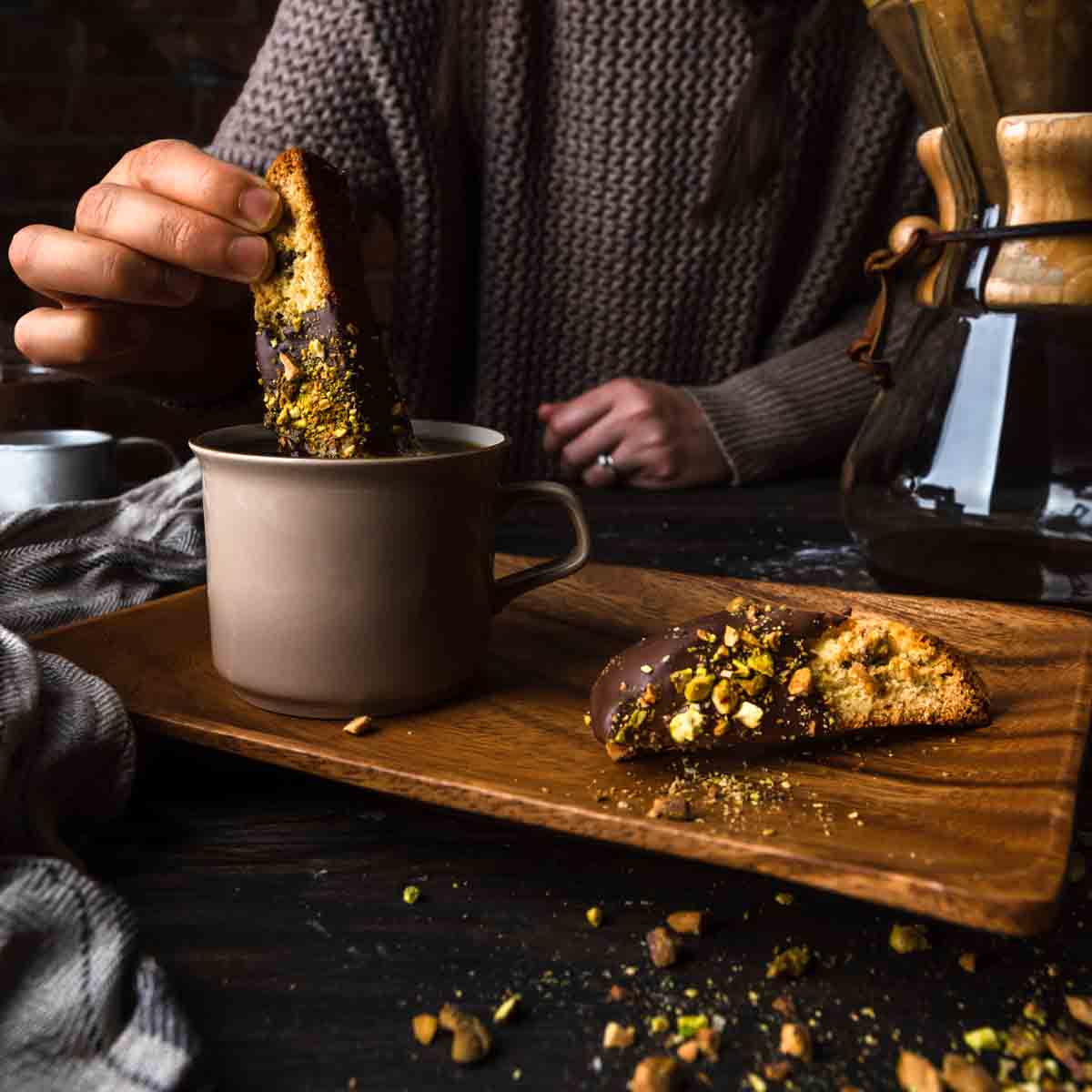 Dipping a pistachio biscotti into a cup of coffee