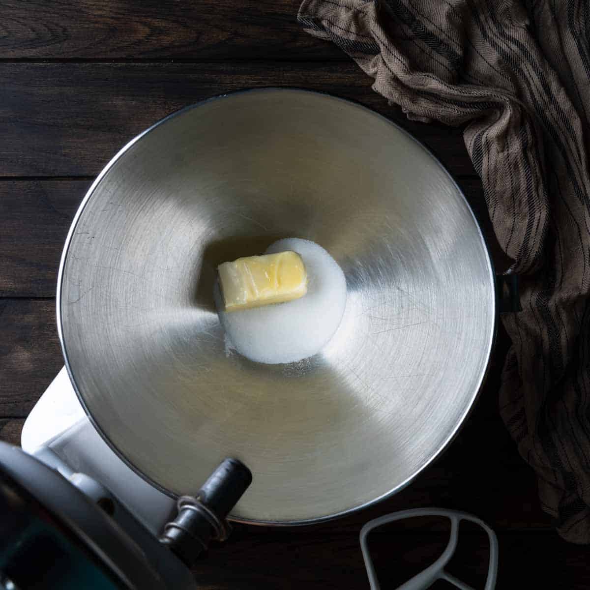 A stand mixer bowl with butter and sugar