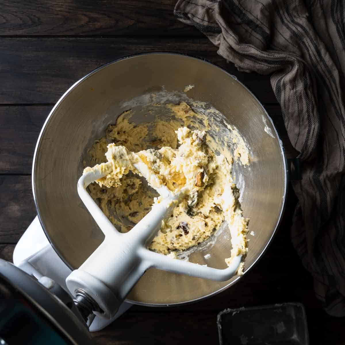 A mixer paddle attachment with pistachio biscotti dough