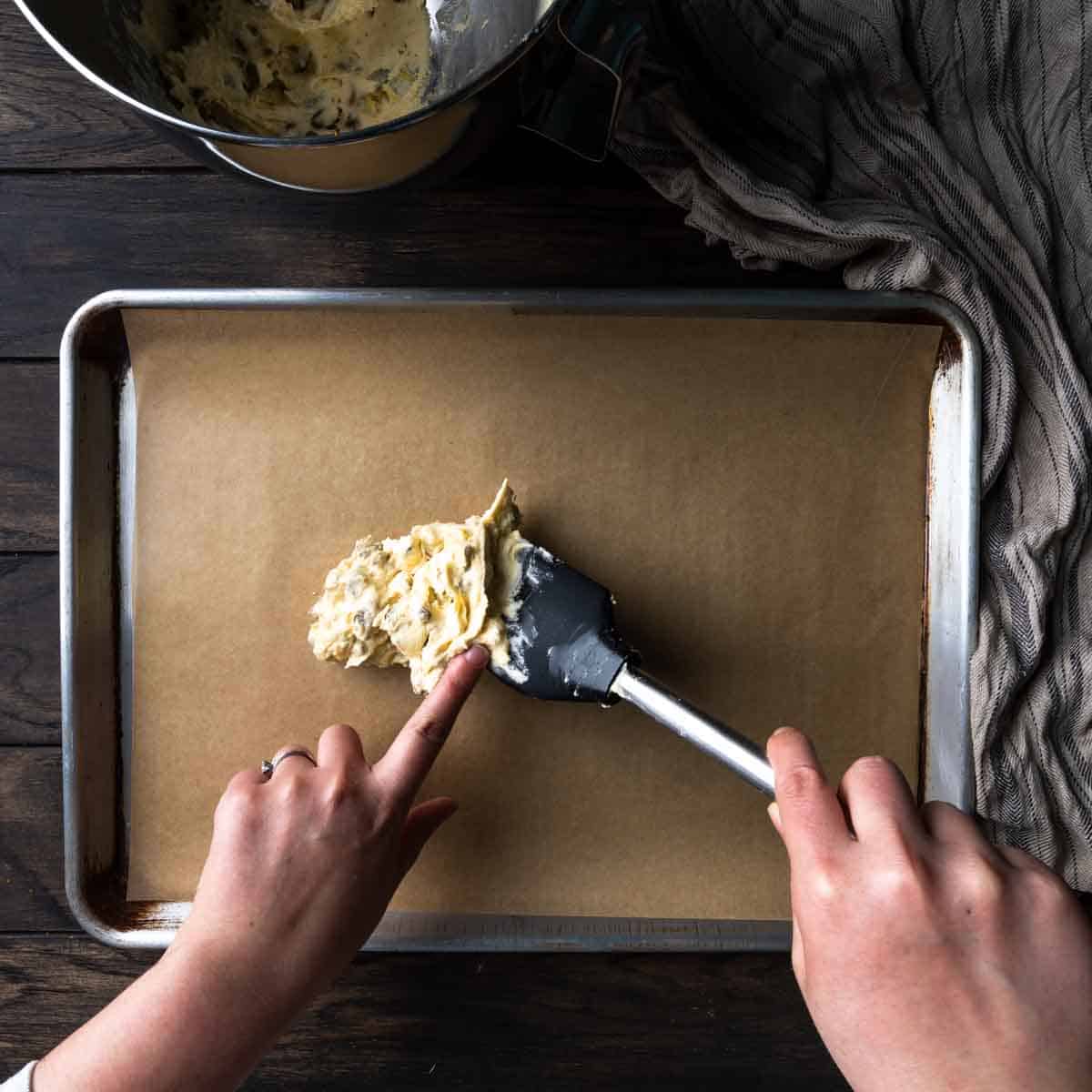 Plopping the dough on a sheet tray with a rubber spatula