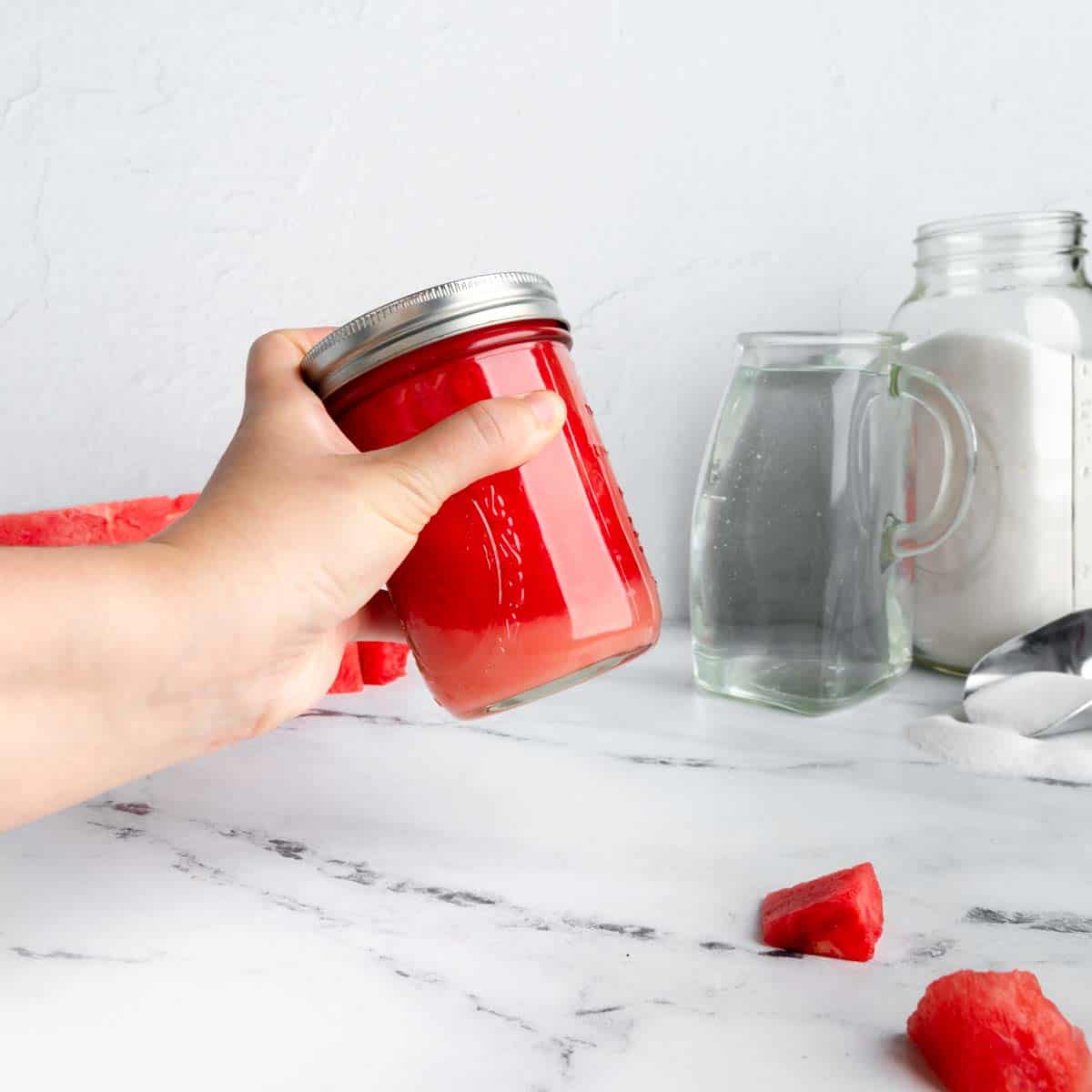 Shaking a jar of sugar and watermelon juice