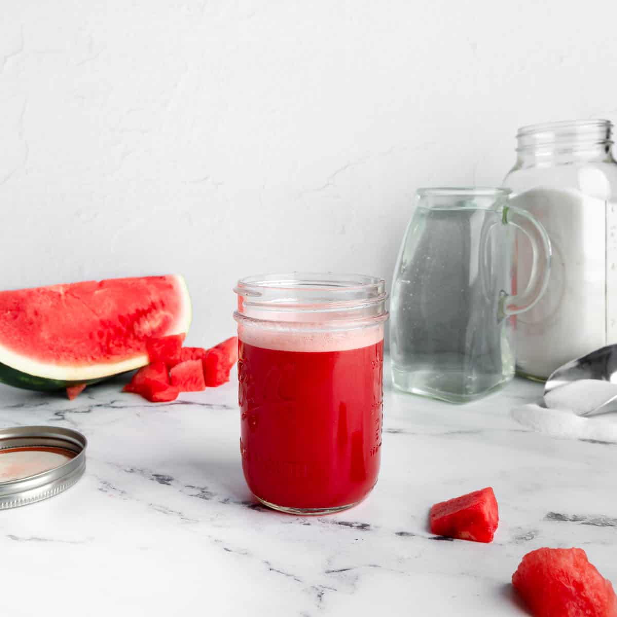 A mason jar full of watermelon syrup