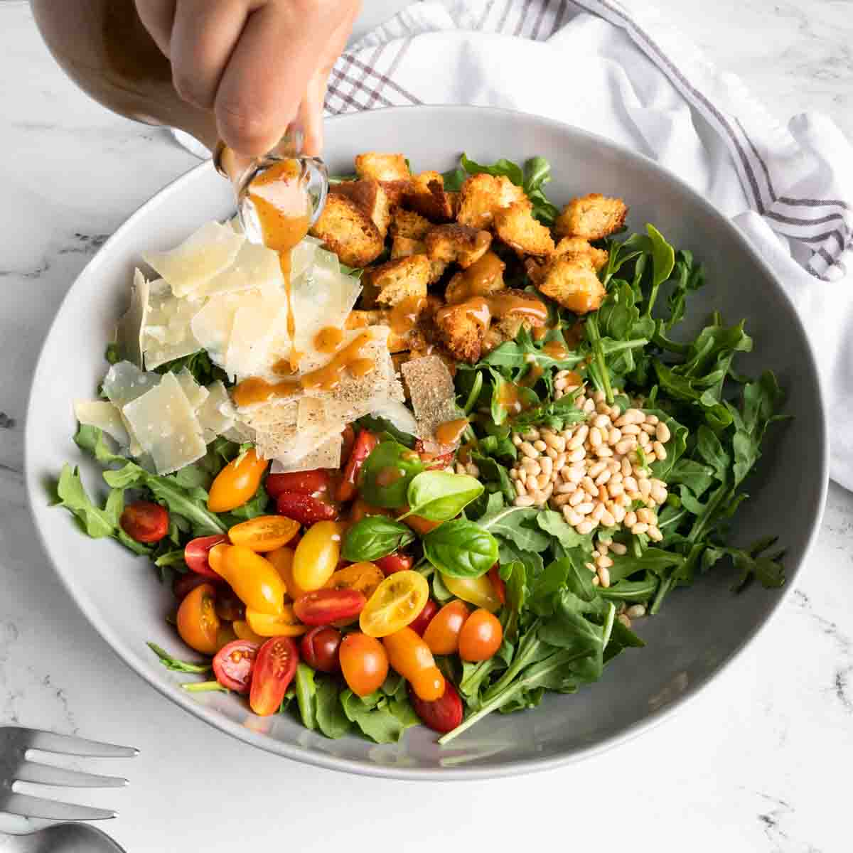 Pouring fig and balsamic vinaigrette over a salad