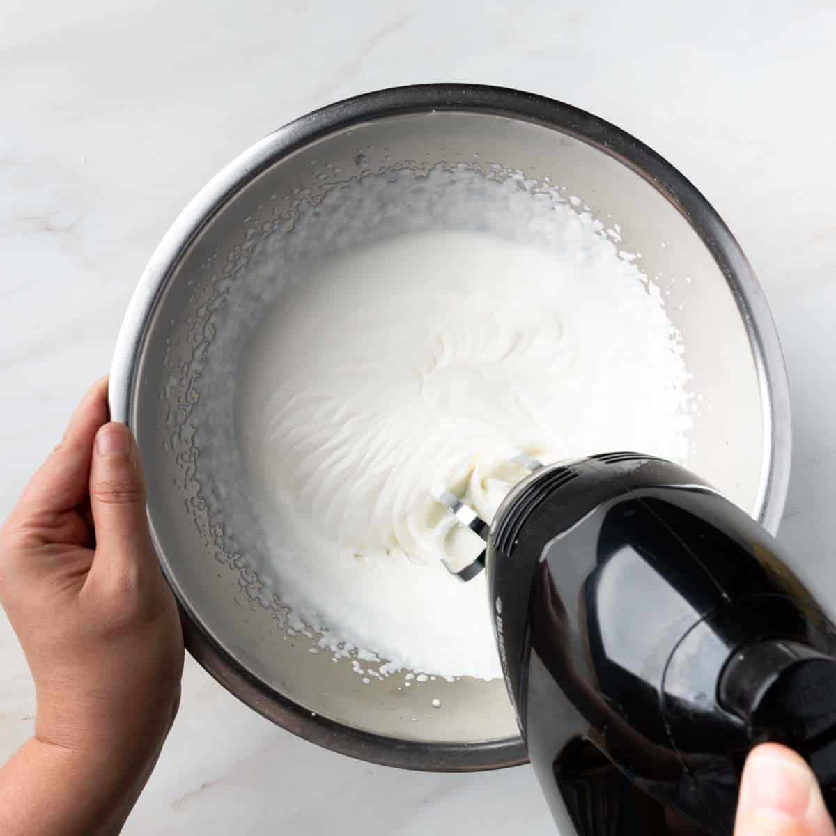 Whipping heavy cream until stiff peaks form