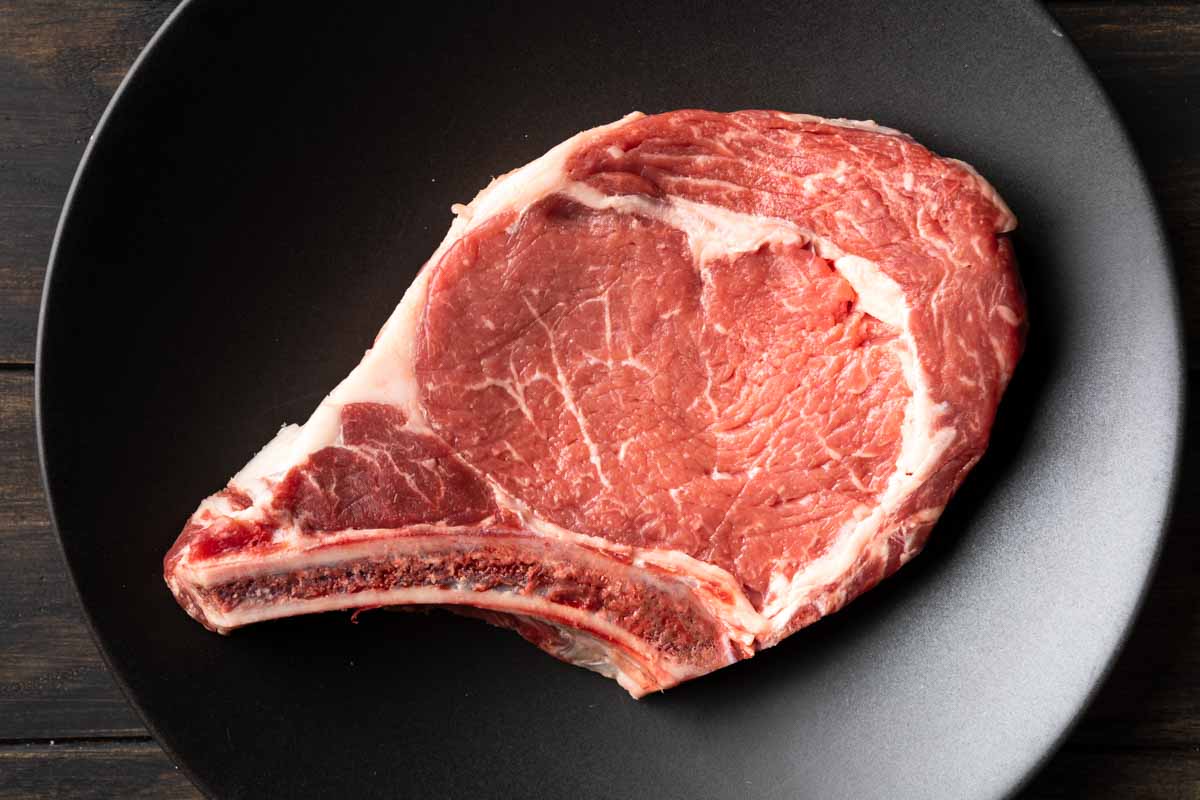A raw choice bone-in ribeye steak