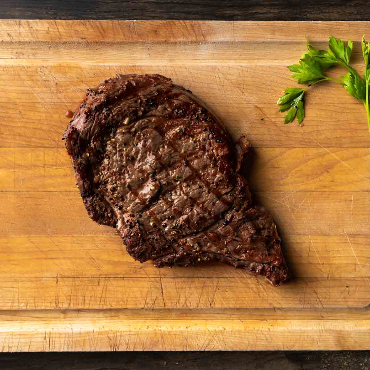 A whole grilled ribeye on a cutting board