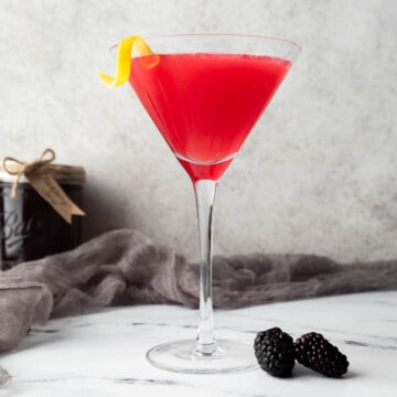 A blackberry lemon drop garnished with a lemon twist