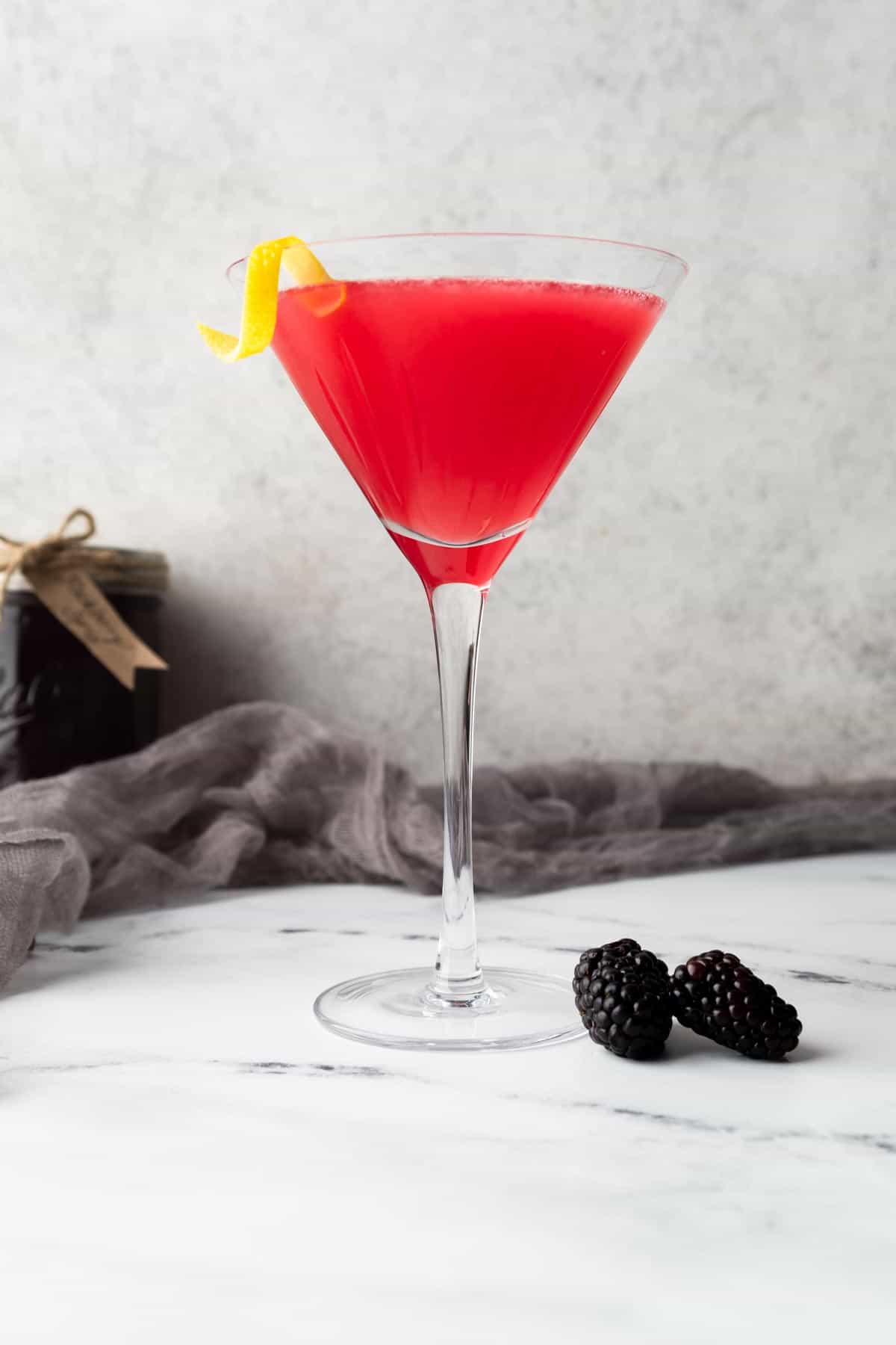 A martini glass filled with a blackberry lemon drop martini