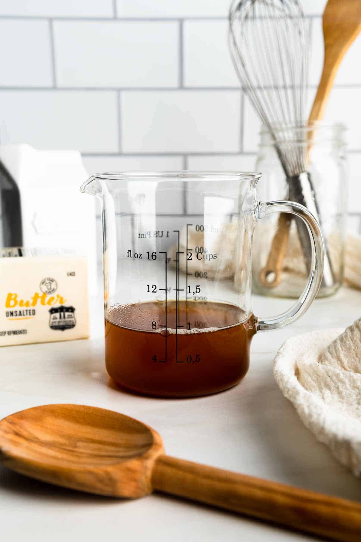Melted brown butter in a glass measuring cup