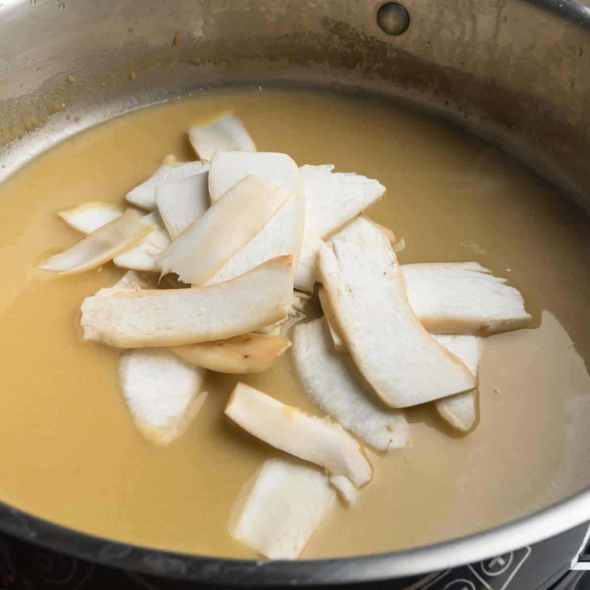 Thinly sliced matsutake stems in a pan of miso butter sauce