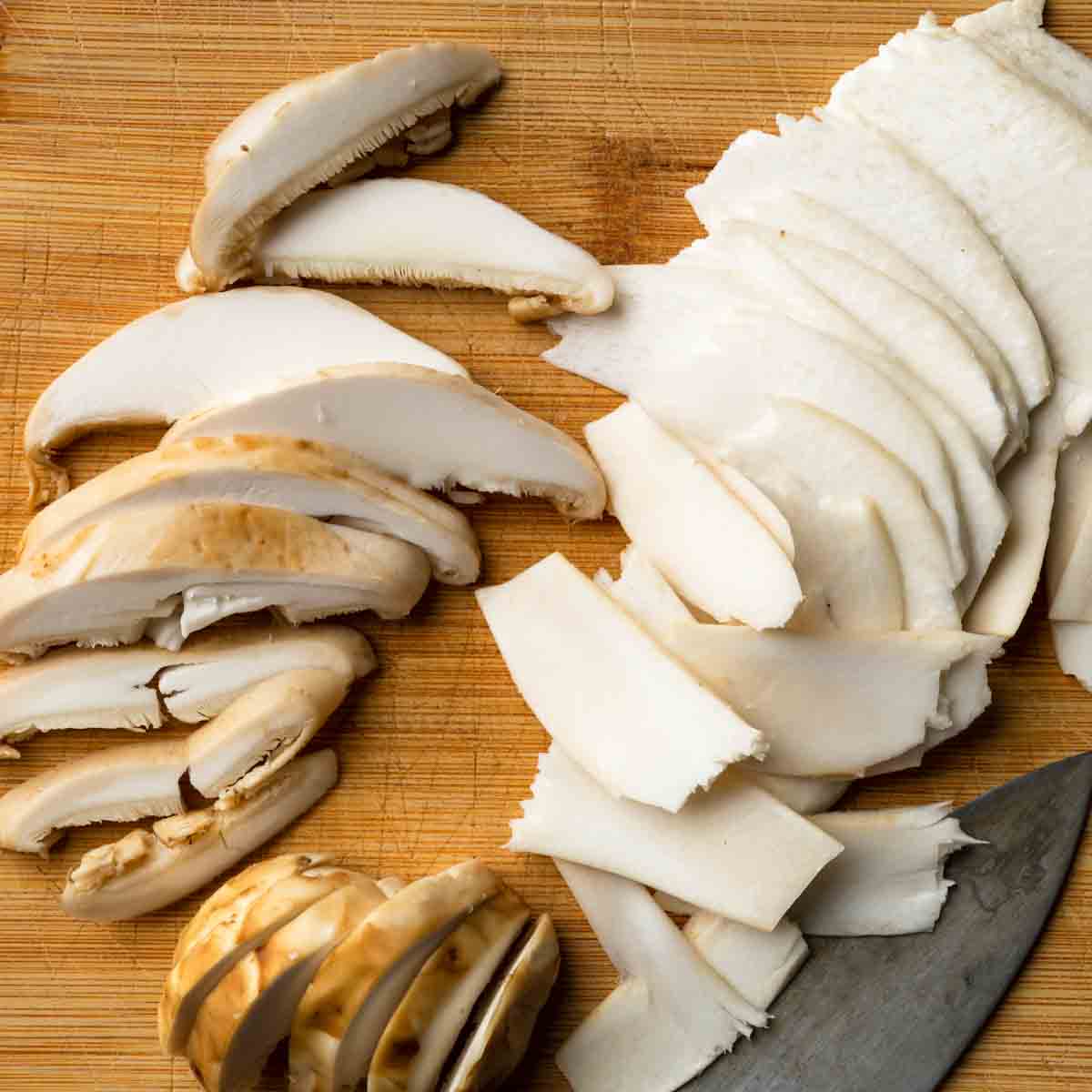 Matsutake mushrooms sliced two ways on a cutting board