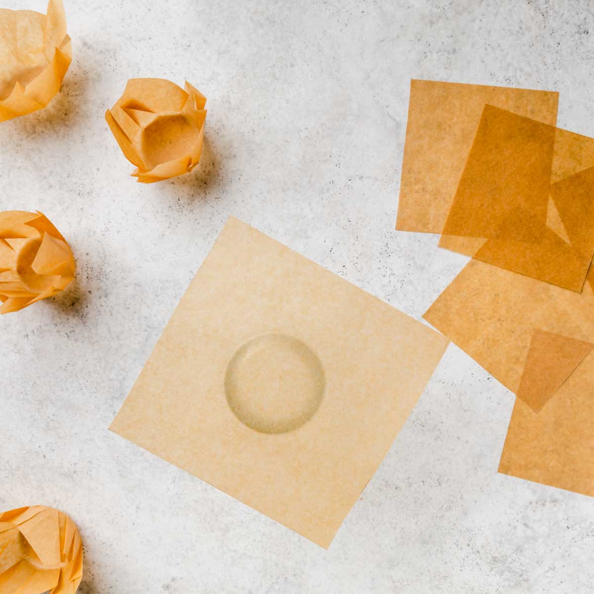 A parchment square laying over the bottom of a glass