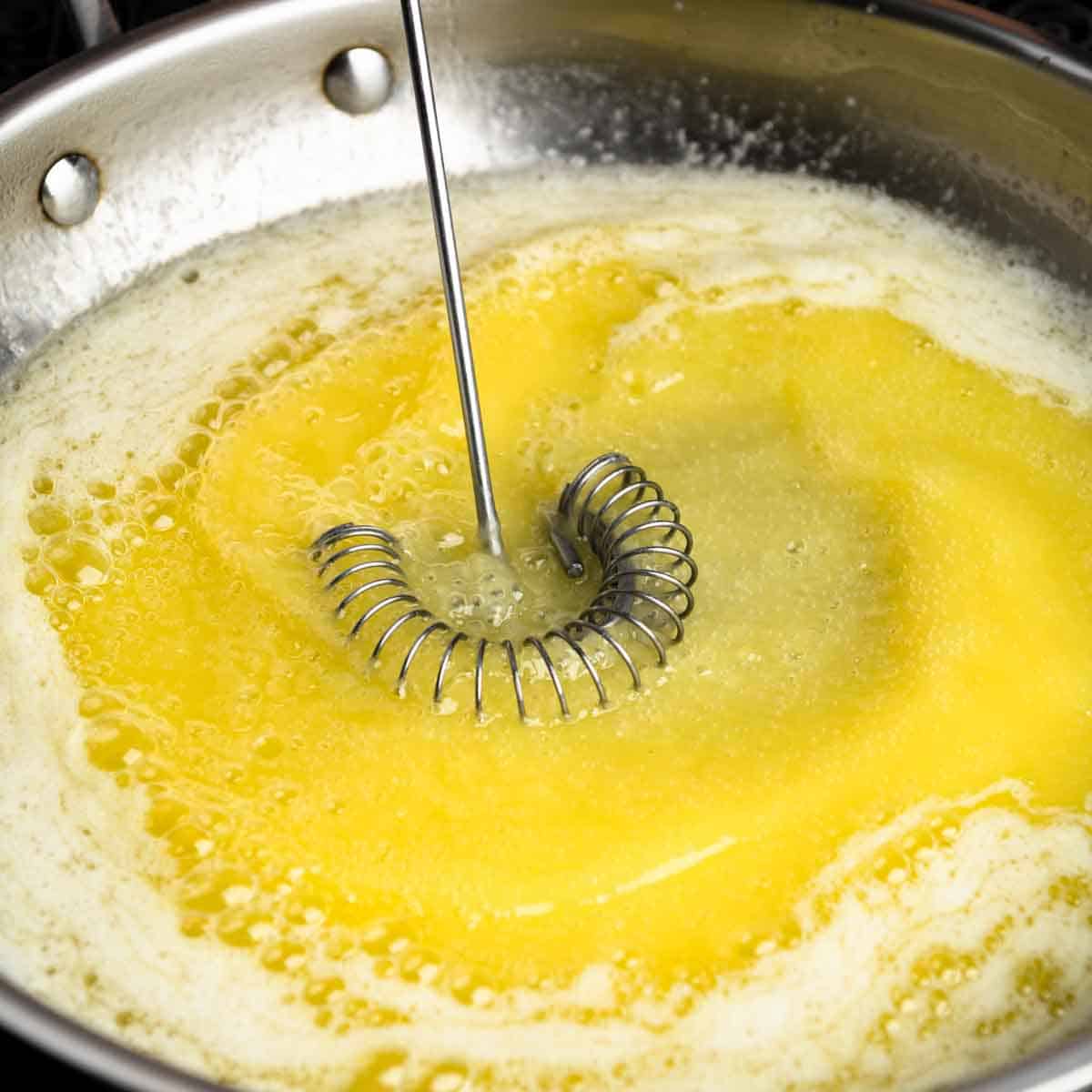 Whisking foamy melted butter in a pan