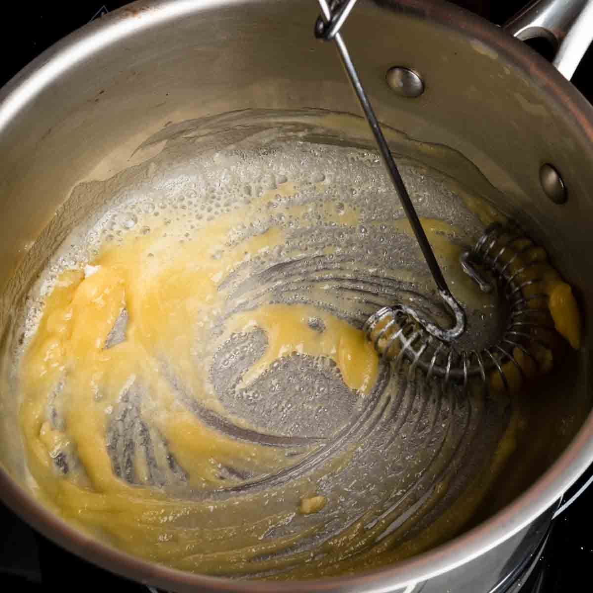 Whisking a roux in a medium sauce pot