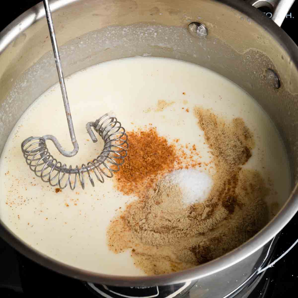 Whisking spices into a béchamel sauce