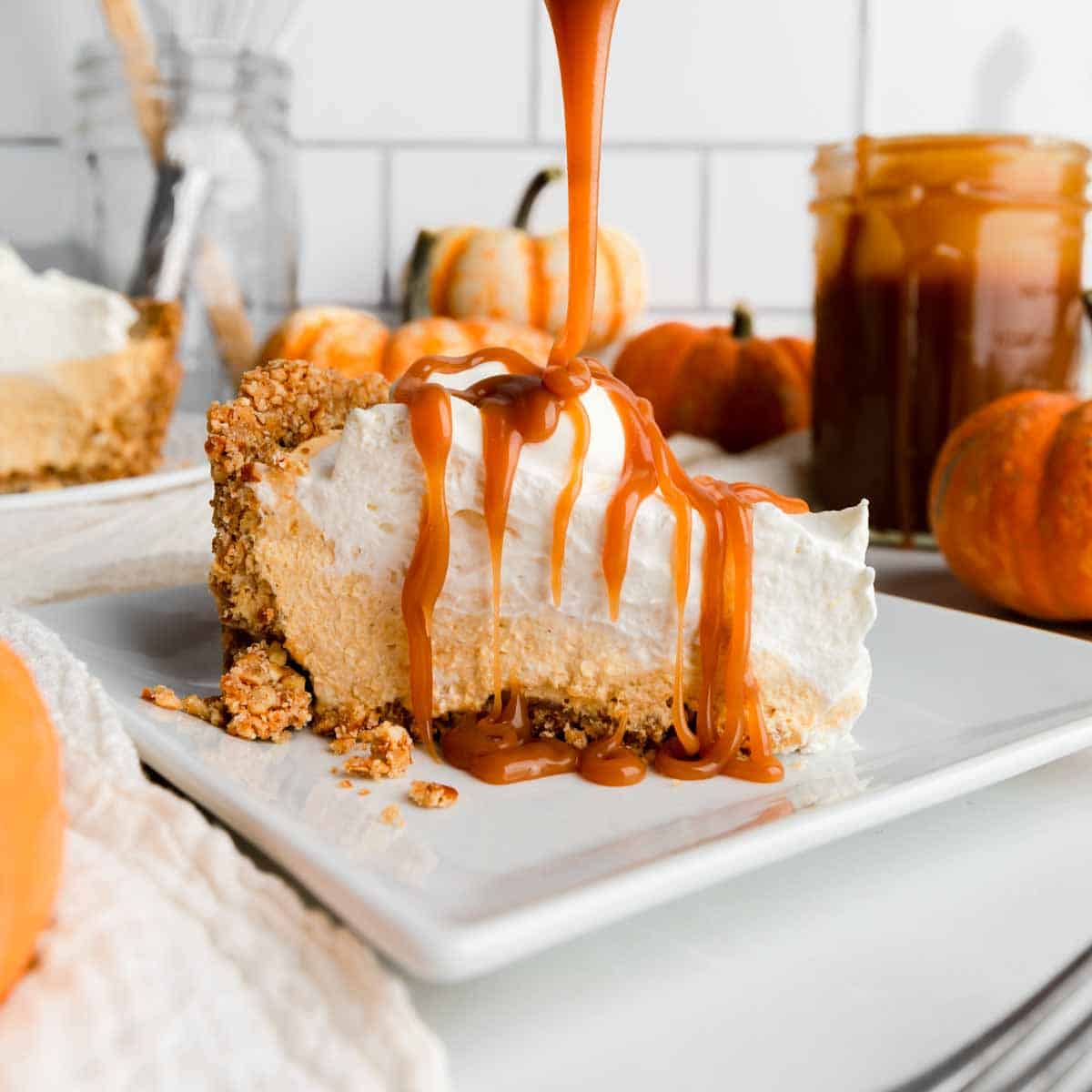 Drizzling homemade caramel sauce over a slice of no bake pumpkin pie