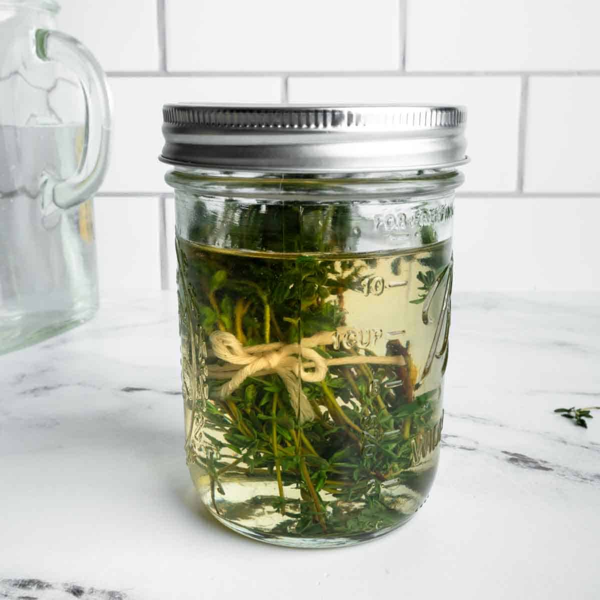 A mason jar of thyme simple syrup.