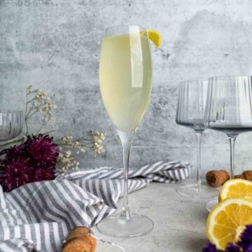 A French 76 cocktail in a Champagne flute garnished with a lemon twist.